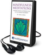 A small, black audio player device with a white cover that has a green-blue, abstract flower illustr