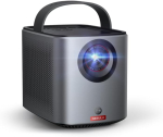 A small gray/black box-shaped projector with a handle, and a lens with light emitting from it.