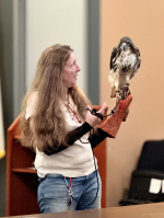 A woman with long hair and a red tailed hawk