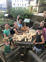 Kids smiling around a toppled Jenga pile.