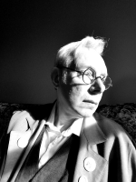 Black and white photo of man in profile with white hair and glasses