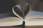 open book with two pages curving together to form a heart shape