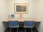 Two desks at a built-in desk are situated in a small room.