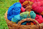 Image of a basket of colorful yarn sitting in the grass