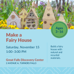 Four small, crafted houses made from cardboard and paper mache placed in a flower garden bed.