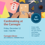 A person's hand holding a bottle of silver glitter glue, which they are applying to a paper card in 