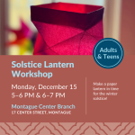 Hand holding red, folded paper lantern.