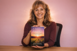 female author holding a copy of the book