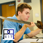 Light skinned young man holding a swrod in two hands