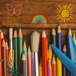 Colored Pencils and other craft supplies on wooden table