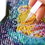 colorful close up of diamond painting with flatback gems and adhesive design sheet.