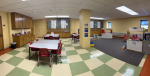 bookable space with multiple tables, chairs, and open space with toys.