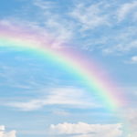 A rainbow in a sky with some clouds.