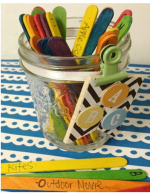 decorated jar with multicolored popsicle sticks inside and in front of jar