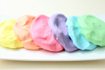 rainbow colors of cloud dough arranged on a plate.
