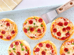 mini pizzas and a spatula 
