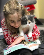 Child reading to a cat.