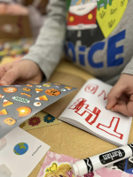 Children putting stickers in a book.