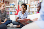 Children sitting in a circle reading books.
