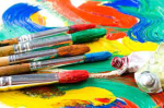 Paintbrushes with paint in the background.