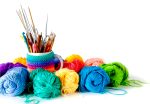 Colorful balls of yarn and a mug full of knit & crochet tools.