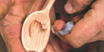 A person carving a spoon.