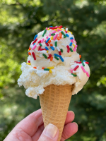 A hand holding an ice cream cone.