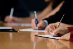 People sitting around a table writing.