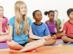 Children sitting in a meditative yoga pose.