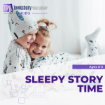 Two toddlers are smiling and hugging while wearing pajamas