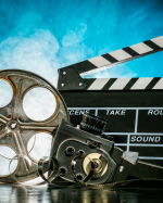 Old fashions film reel, camera, and clap board on blue background