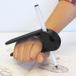 A person using a tool to assist in holding a pen.