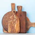 a group of wooden cutting boards against a blue background.