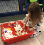 Child playing with shaving cream and toys