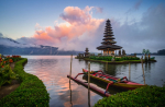Tiered temple on an island with a brightly colored boat in the foreground.