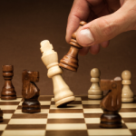 A dark wood pawn taking a white bishop.