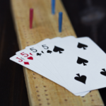 Cribbage board and hand of cards.