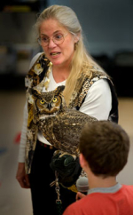 Lady showing a Great Horned Owl to a child.
