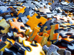 Close up of blue and yellow puzzle pieces.