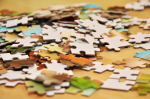 Close up of multi-color puzzle pieces on a wooden table.