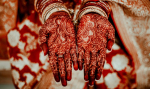 A traditional bridal henna design from Production by RNK where the bride holds out her hands palm fo