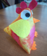 A bright orange, yellow, red, and white fabric chicken.