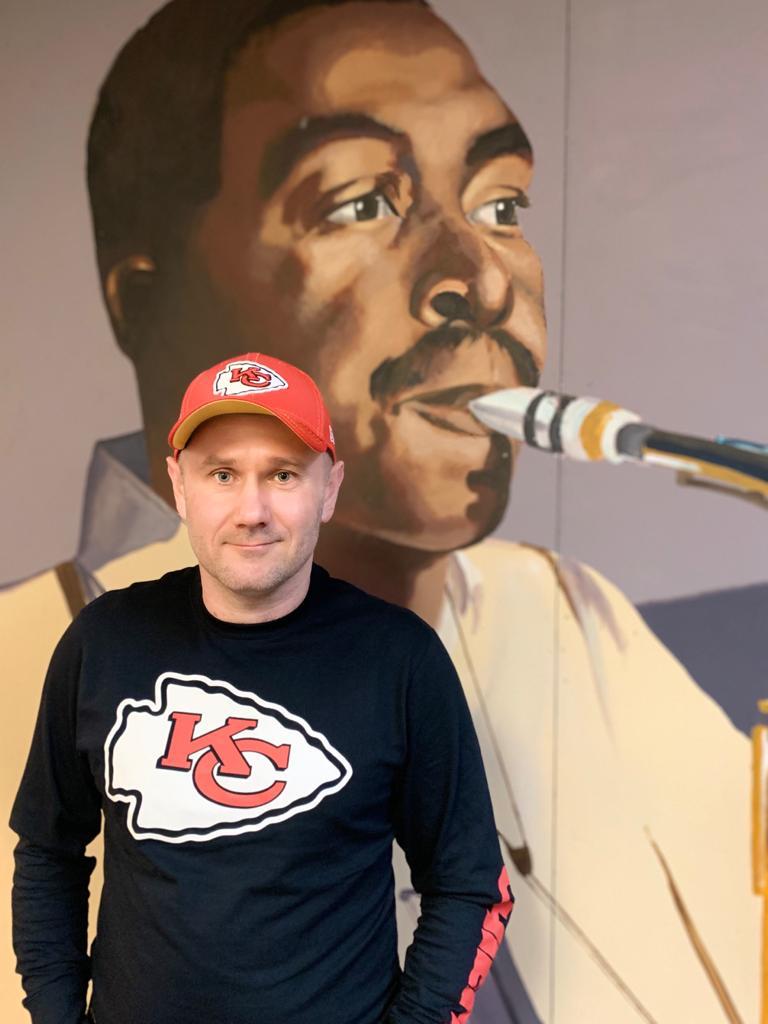 Sylwester Ostrowski in Front of a Charlie Parker Art at KKFI Studios in Kansas City-Half