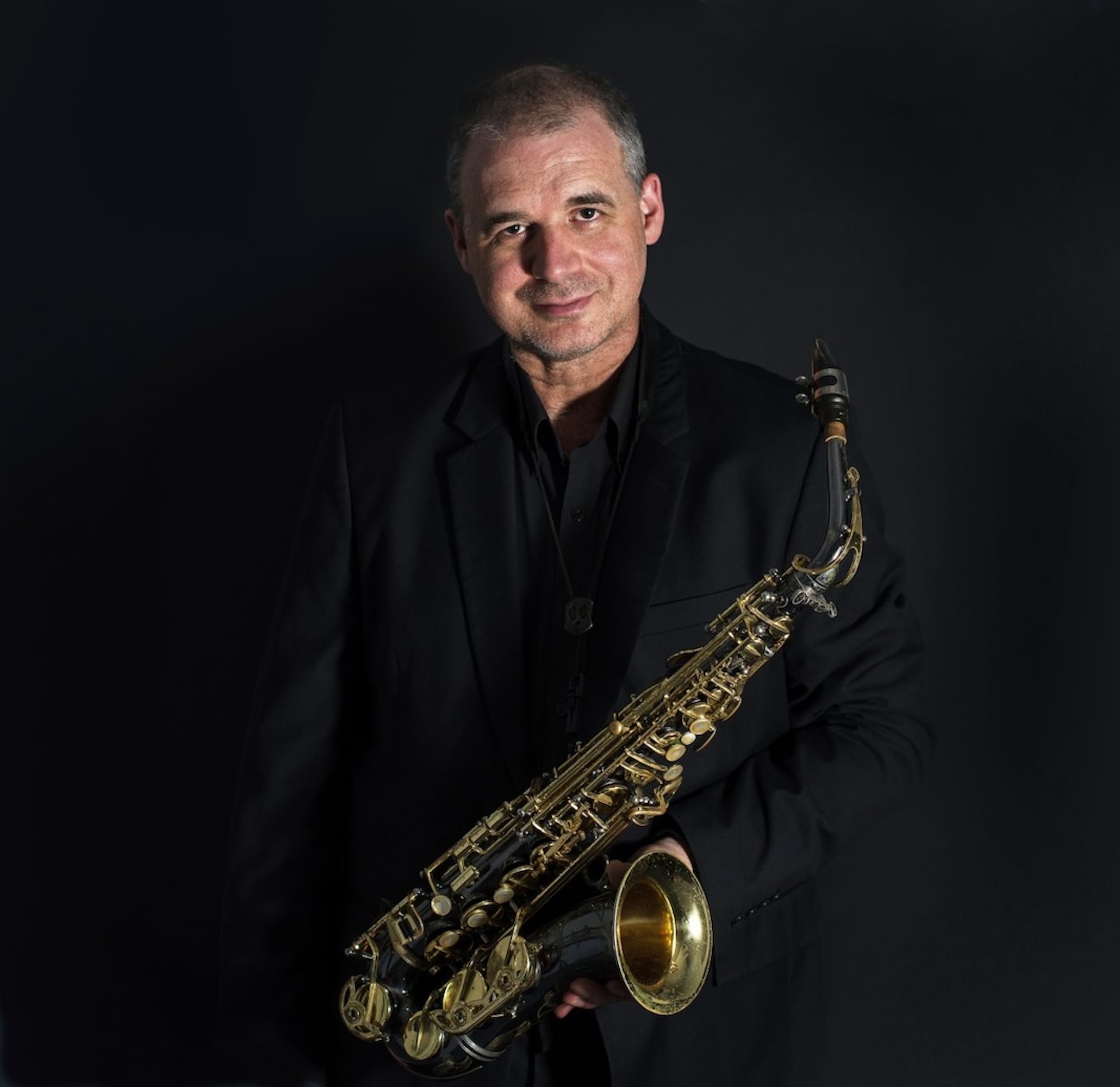 A casual dark background photo of Andy Firth with Alto Sax — jazz photo by Andy Firth | All About Jazz