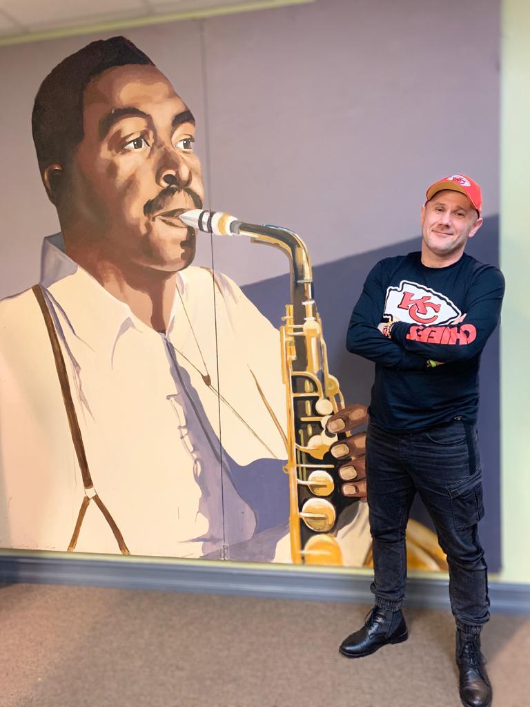 Sylwester Ostrowski in Front of a Charlie Parker Art at KKFI Studios in Kansas City-Full