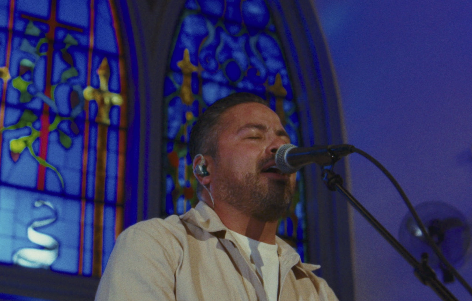 Cantante frente a vitrales en iglesia