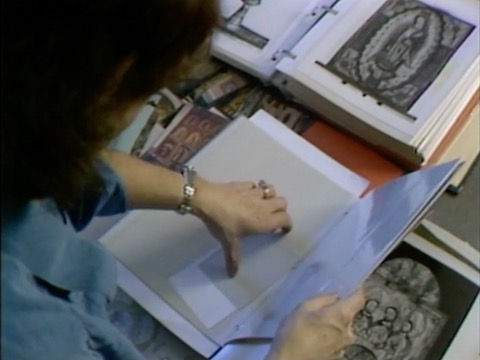 thumbnail of Library Footage. Woman Looking Through Religious Images