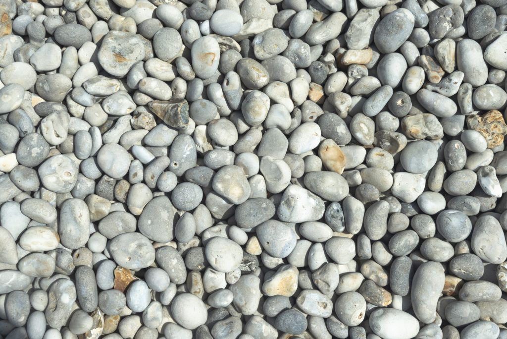 All rounded tiny pebbles from beach a natural summer background smooth polished pebble stones