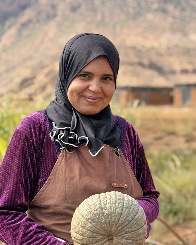 Fatima holding a pumpkin in the fields of Aït Bouguemez
