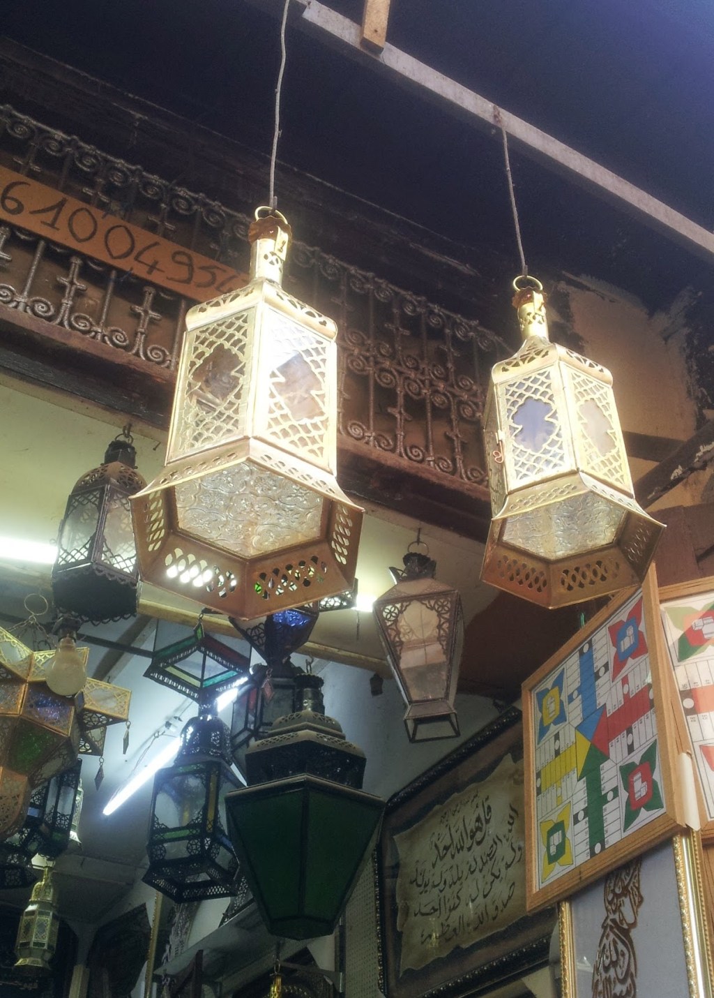 Two recently made lanterns hang above Mohssine's shop. A board game Mohssine made hangs on the wall.